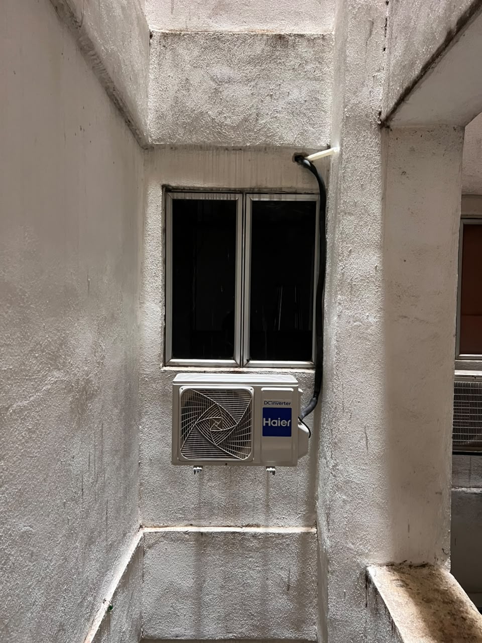 Outdoor aircond unit mounted in an apartment air well