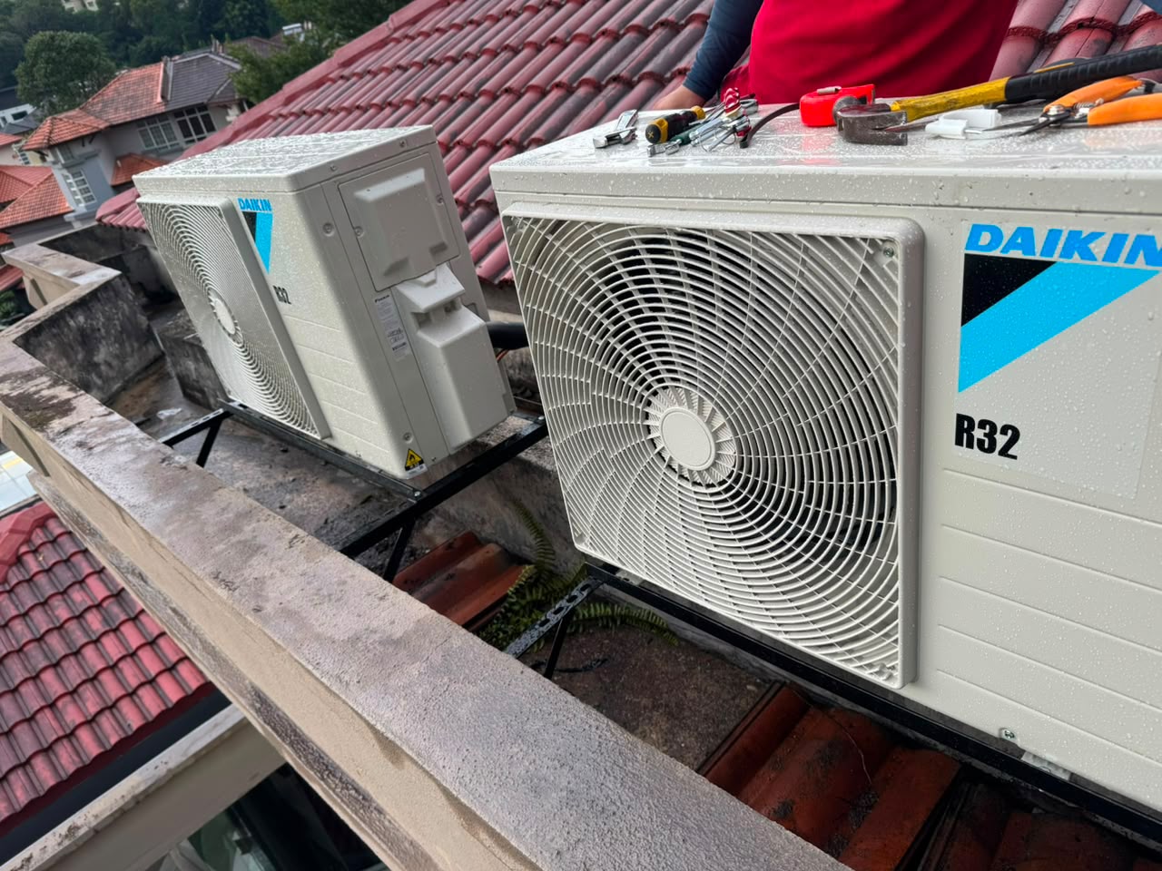 Two new outdoor aircond units on brackets beside roof tiles