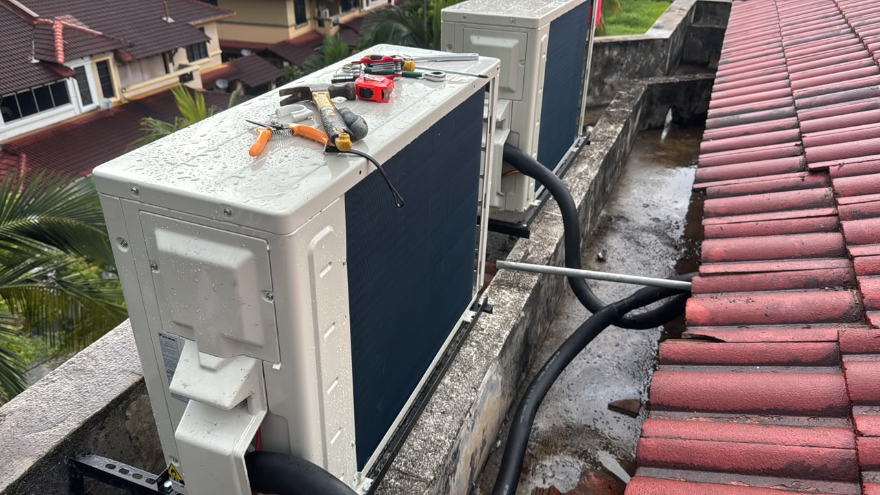 Two new outdoor aircond units on a roof ledge with tools resting on top